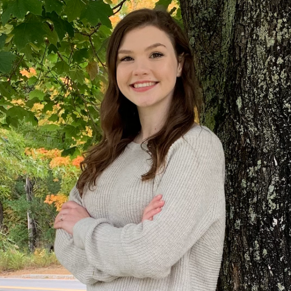 Headshot photo of Elizabeth Mellen outside leaning against a tree